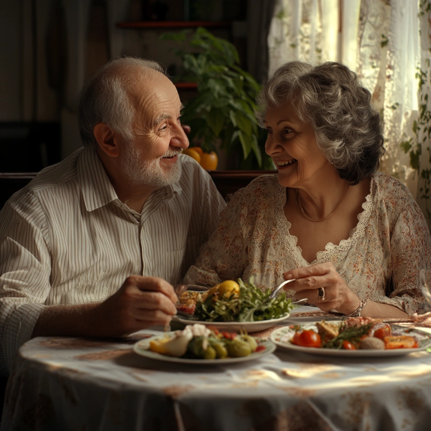 Щасливе подружжя пенсіонерів насолоджується здоровою їжею за столом